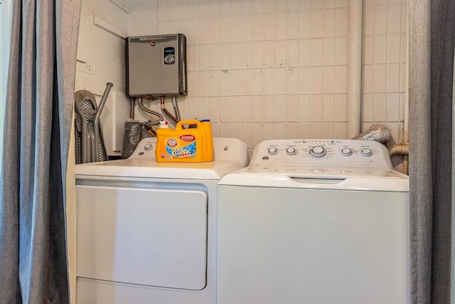 laundry room featuring separate washer and dryer and tile walls