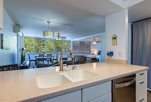 kitchen featuring a wall mounted air conditioner, dishwasher, white cabinets, sink, and hanging light fixtures