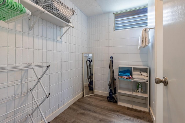 laundry area with dark hardwood / wood-style floors and tile walls