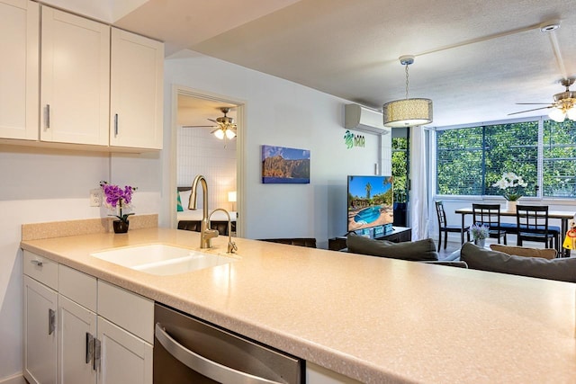 kitchen with white cabinets, sink, hanging light fixtures, stainless steel dishwasher, and a wall mounted AC