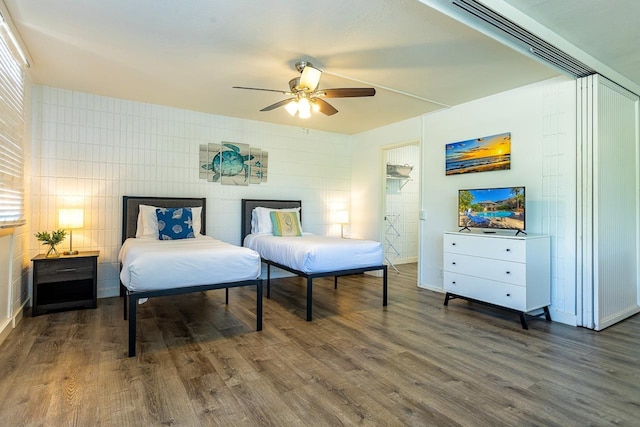 bedroom featuring a closet, dark hardwood / wood-style floors, a spacious closet, and ceiling fan