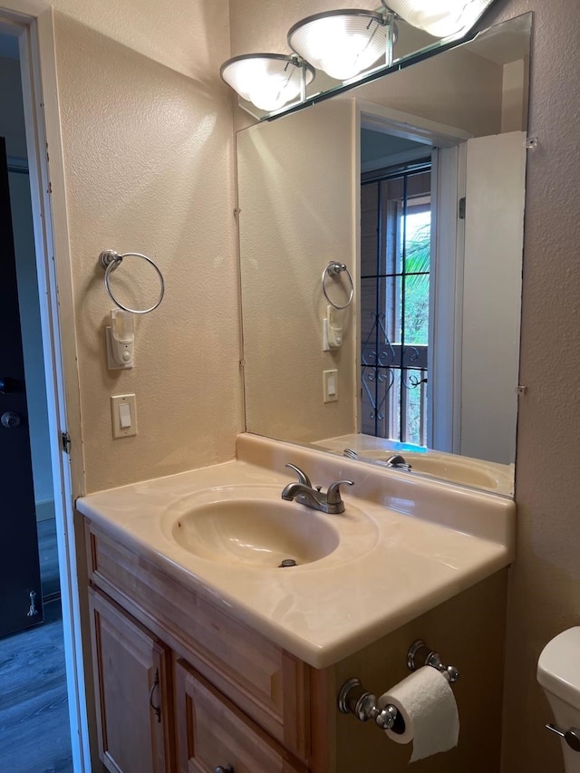 bathroom featuring hardwood / wood-style floors, vanity, and toilet