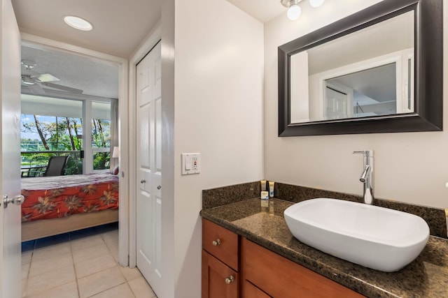 ensuite bathroom with ceiling fan, tile patterned flooring, vanity, and connected bathroom