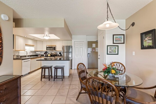 dining area with light tile patterned floors and a textured ceiling