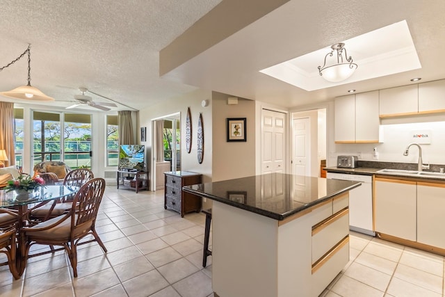 kitchen featuring a sink, ceiling fan, light tile patterned floors, white dishwasher, and a kitchen island