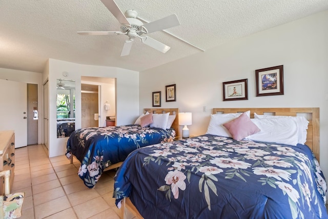 bedroom with a ceiling fan, connected bathroom, light tile patterned flooring, and a textured ceiling