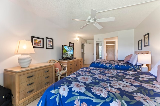 bedroom with light colored carpet, ceiling fan, and a textured ceiling