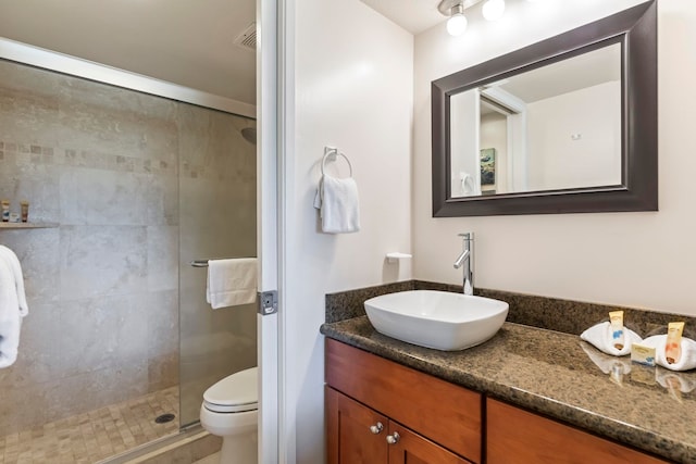 bathroom featuring vanity, toilet, and a shower stall