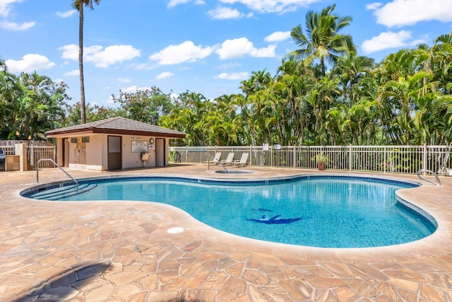 community pool with fence and a patio