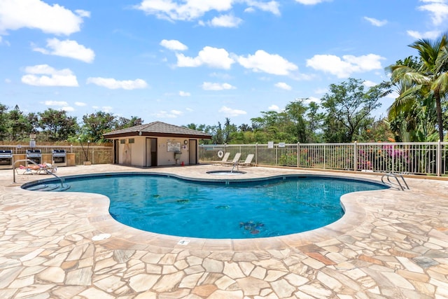 community pool with a patio and fence