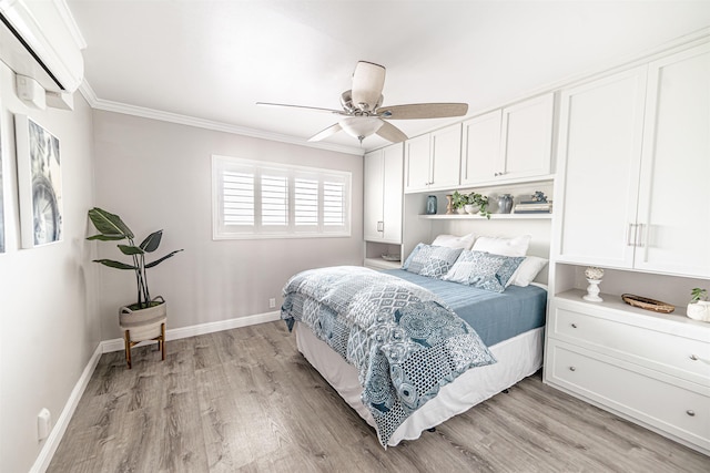 bedroom featuring a ceiling fan, light wood-type flooring, a wall mounted air conditioner, baseboards, and ornamental molding