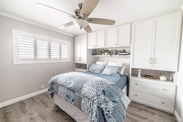 bedroom featuring baseboards, crown molding, light wood-style flooring, and a ceiling fan
