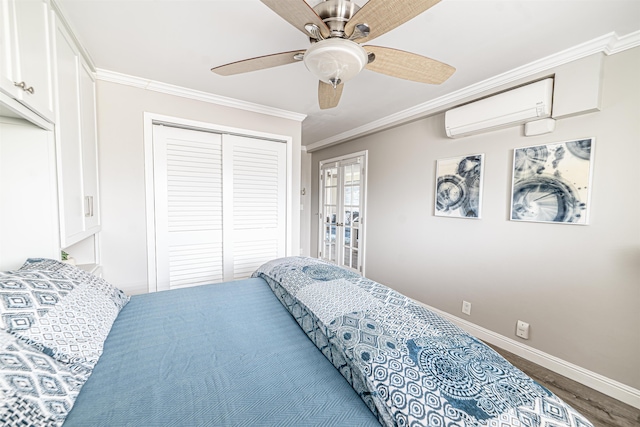 bedroom with a closet, crown molding, wood finished floors, baseboards, and an AC wall unit