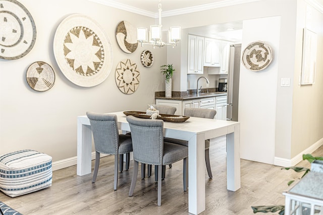 dining area featuring baseboards, a notable chandelier, light wood-style flooring, and ornamental molding