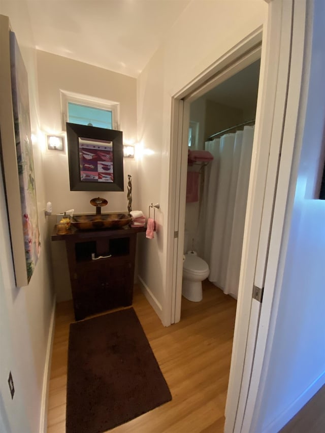 bathroom featuring hardwood / wood-style floors and toilet