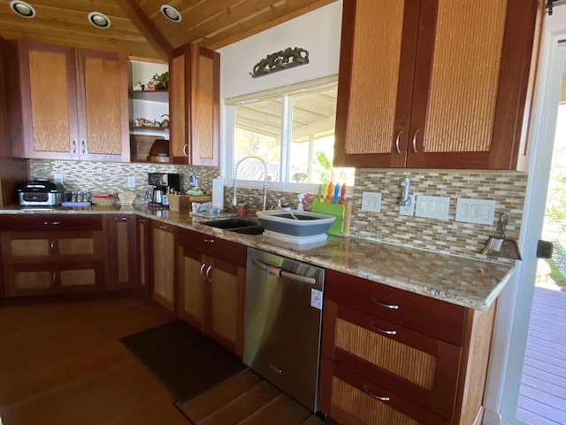 kitchen featuring light stone countertops, tasteful backsplash, stainless steel dishwasher, vaulted ceiling, and sink