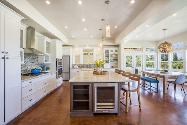 kitchen with beverage cooler, appliances with stainless steel finishes, finished concrete flooring, and wall chimney exhaust hood