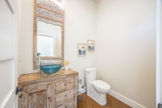 bathroom with baseboards, toilet, vanity, and tile patterned flooring