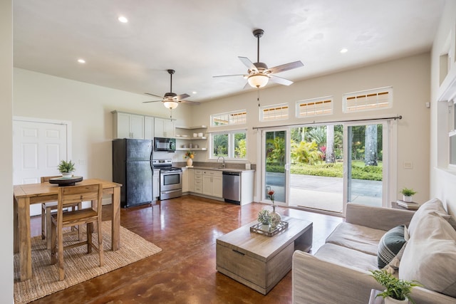 living area with recessed lighting, concrete floors, a ceiling fan, and a healthy amount of sunlight