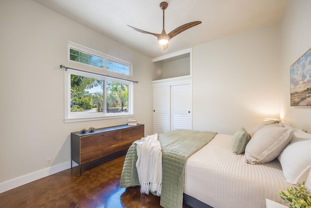 bedroom featuring a closet, baseboards, concrete floors, and a ceiling fan