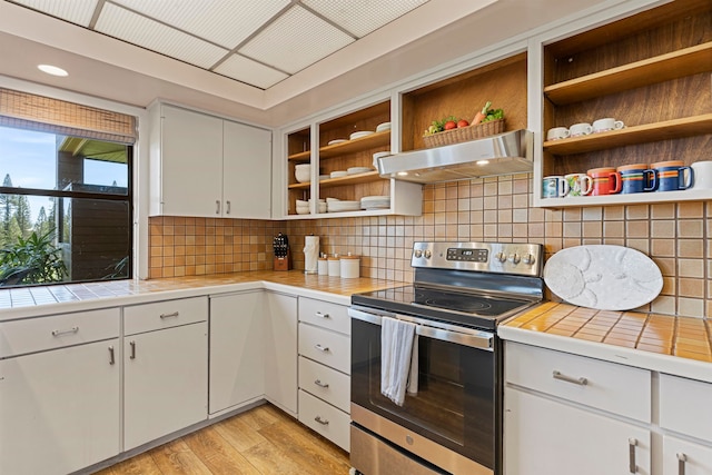 kitchen featuring white cabinetry, ventilation hood, tile countertops, electric stove, and light wood-type flooring