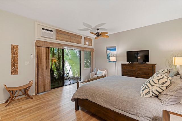 bedroom featuring access to outside, light hardwood / wood-style flooring, an AC wall unit, and ceiling fan