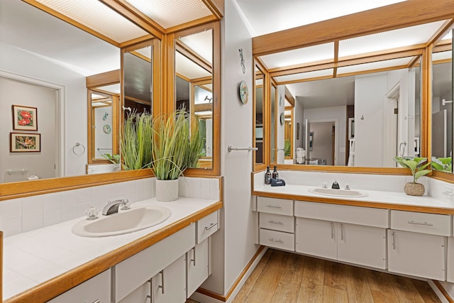 bathroom featuring decorative backsplash, hardwood / wood-style flooring, and vanity