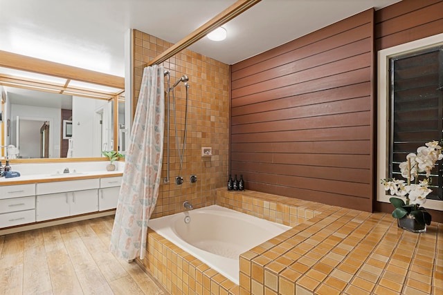 bathroom with shower / bathtub combination with curtain, hardwood / wood-style floors, and vanity