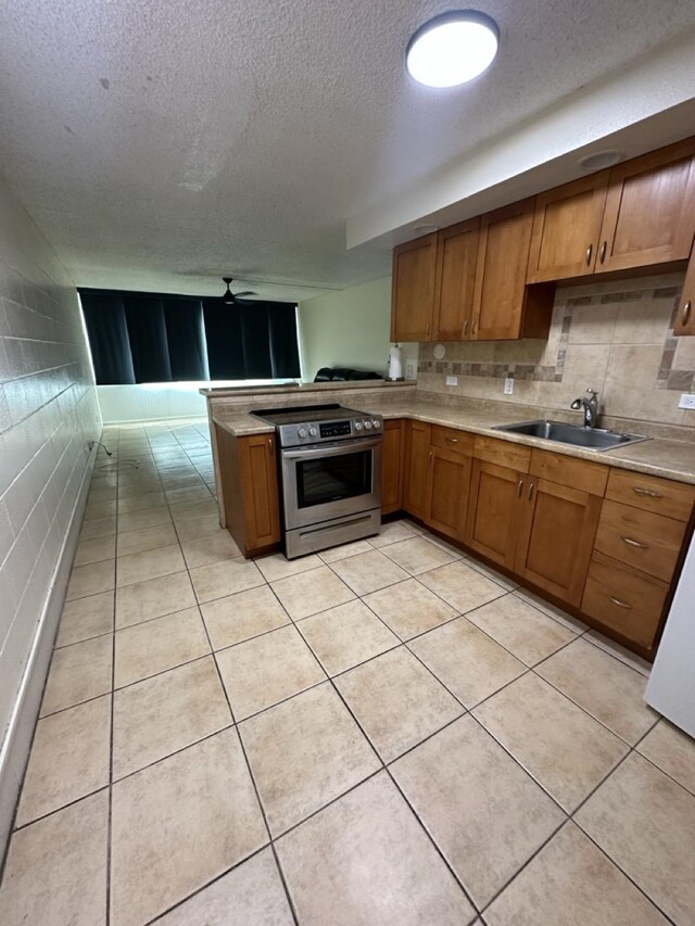 111 Kahului Beach Rd Unit A407, Kahului, HI 96732 - kitchen featuring brown cabinetry, a sink, stainless steel range with electric cooktop, and ceiling fan