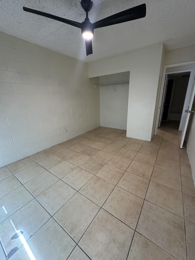 111 Kahului Beach Rd Unit A407, Kahului, HI 96732 - unfurnished bedroom with a ceiling fan, a closet, concrete block wall, and a textured ceiling