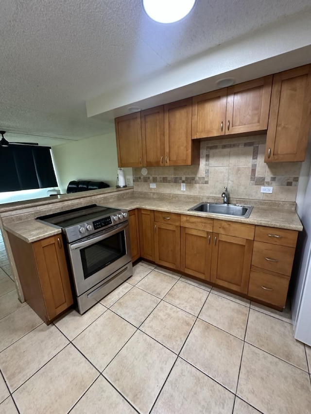 111 Kahului Beach Rd Unit A407, Kahului, HI 96732 - kitchen with electric range, brown cabinets, a sink, and a textured ceiling