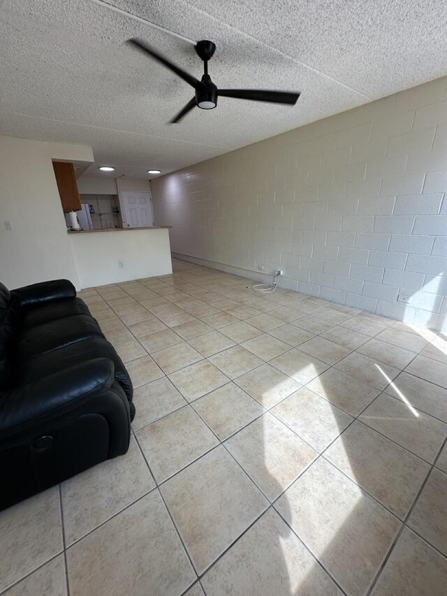 111 Kahului Beach Rd Unit A407, Kahului, HI 96732 - living area with a textured ceiling, light tile patterned flooring, a ceiling fan, and concrete block wall