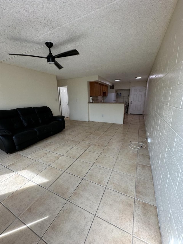 111 Kahului Beach Rd Unit A407, Kahului, HI 96732 - living area with light tile patterned floors, a textured ceiling, concrete block wall, and ceiling fan