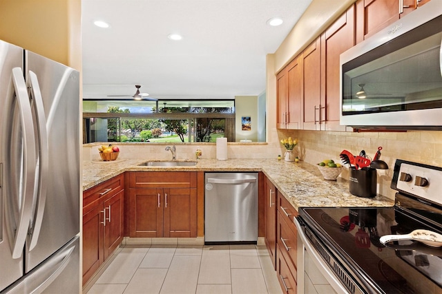 kitchen with sink, ceiling fan, light stone countertops, appliances with stainless steel finishes, and light tile patterned flooring