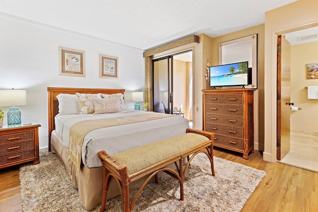 bedroom featuring light hardwood / wood-style floors and a textured ceiling