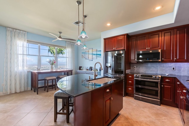 kitchen with dark countertops, a ceiling fan, appliances with stainless steel finishes, and dark brown cabinets