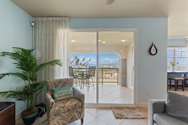 sitting room with ceiling fan and tile patterned flooring