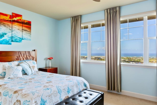 bedroom featuring light carpet and baseboards