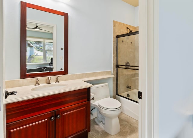 full bathroom featuring toilet, a ceiling fan, vanity, enclosed tub / shower combo, and tile patterned flooring