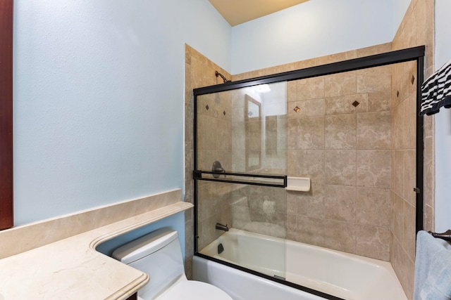 full bathroom featuring toilet and shower / bath combination with glass door