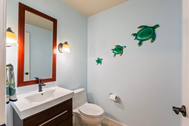 half bathroom with toilet and vanity