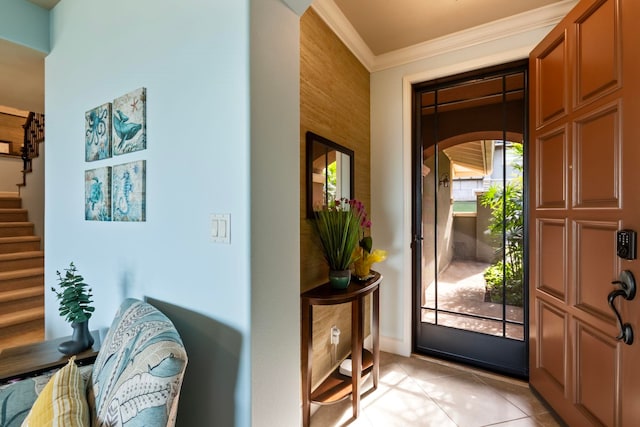 foyer entrance featuring light tile patterned flooring, stairway, and crown molding