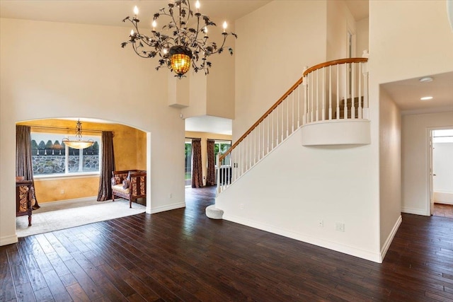 entrance foyer with dark hardwood / wood-style flooring, high vaulted ceiling, and a wealth of natural light