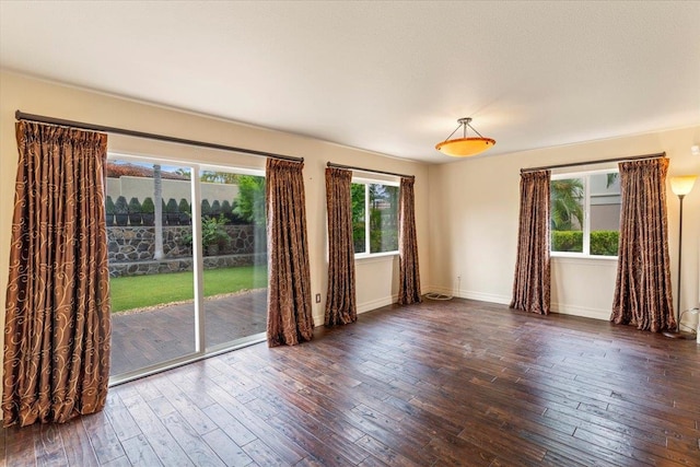 unfurnished room with dark hardwood / wood-style flooring