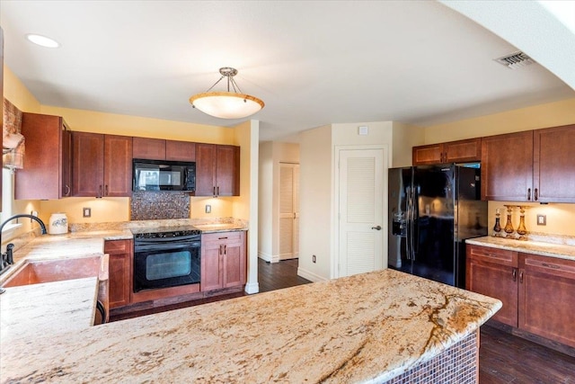 kitchen featuring dark wood-type flooring, black appliances, sink, and pendant lighting