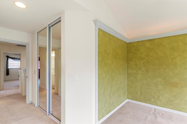 corridor featuring vaulted ceiling and light colored carpet