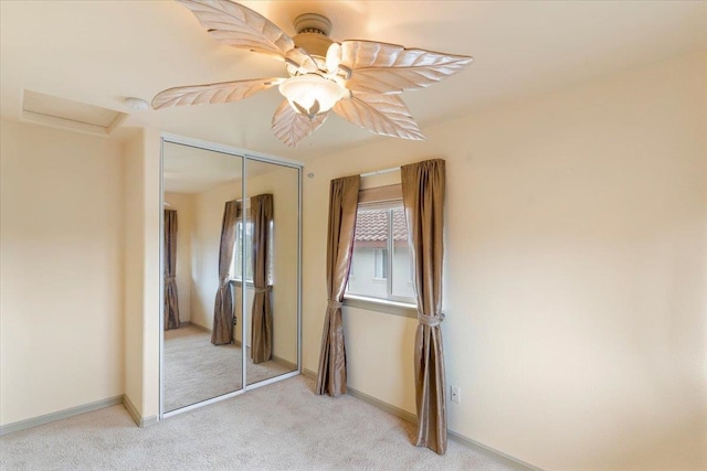 unfurnished bedroom featuring light colored carpet, a closet, and ceiling fan