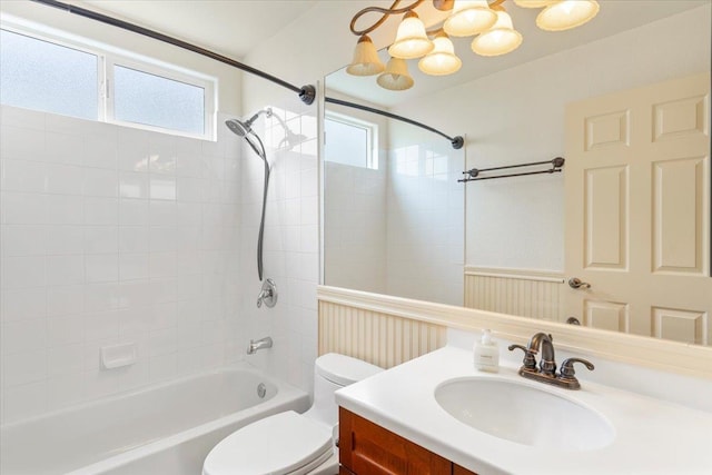 full bathroom featuring vanity, tiled shower / bath combo, and toilet