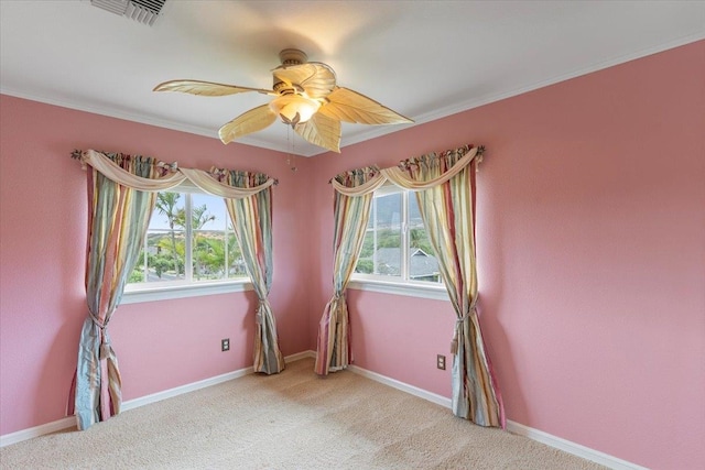 spare room with ceiling fan, ornamental molding, and light colored carpet