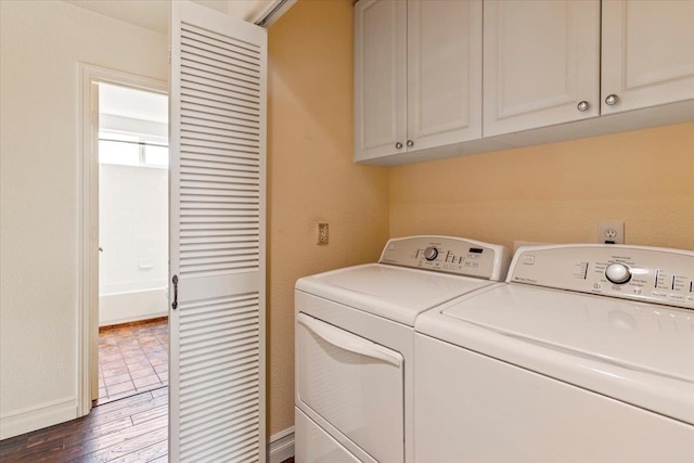 washroom with dark wood-type flooring, independent washer and dryer, and cabinets